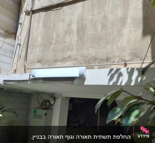 תמונה של קיר עם צינורות חשמל ותאורה חיצונית